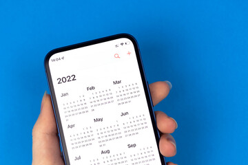 Calendar for 2022 on smartphone screen. Close-up view. New year planning concept photo