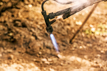Close-up of the hand of an industrial worker working on the process of cutting rails.