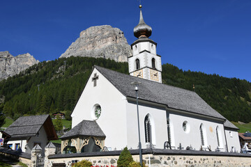 Fototapeta na wymiar Kolfuschg, ladinisch Calfosch, italienisch Colfosco ist ein Dorf in Südtirol, Ladinien in Italien. Es liegt in den Dolomiten in der Ferienregion Alta Badia. Kirche St. Vigil und der Berg Sassongher. 