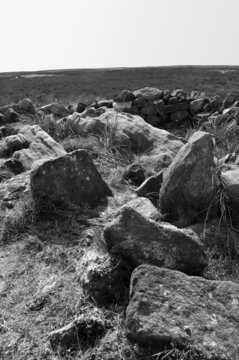 exposed stones at the top of a cairn known as the millers grave on midgley moor in calderdale west yorkshire with pennine moorland scenery
