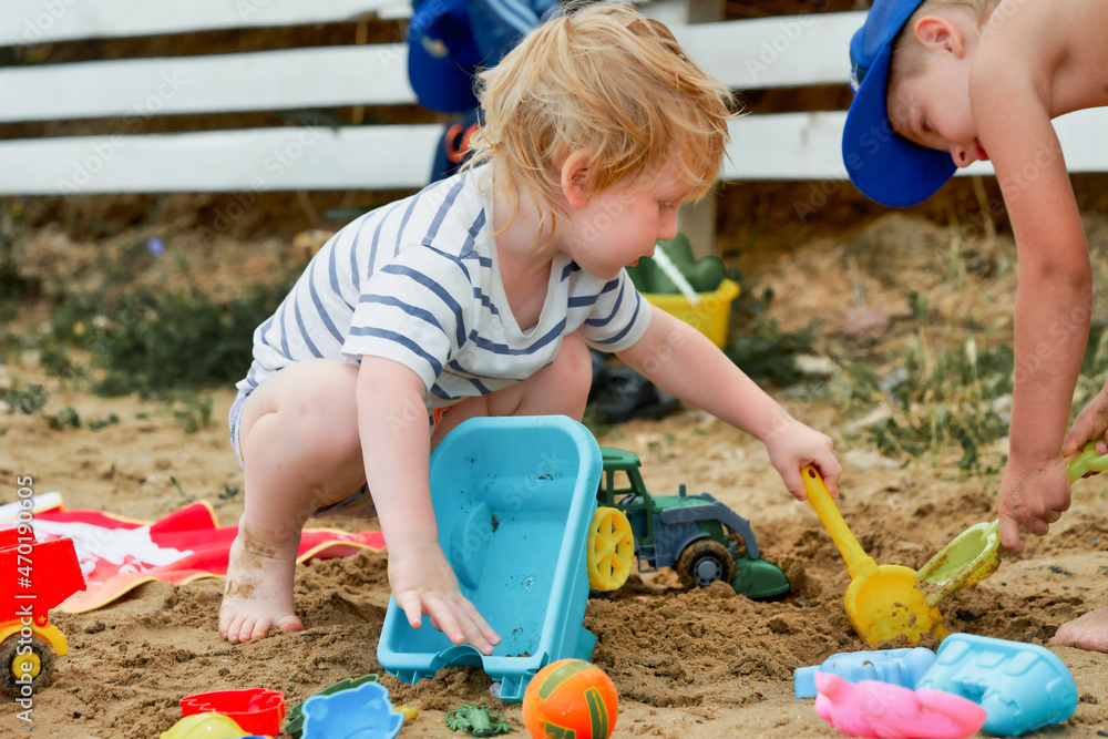 Canvas Prints two children play in the sand with plastic toys