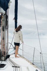 Young Woman on a sailboat looking at the ocean