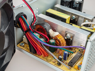 Disassembled computer power supply for repair, internal device of the PSU, capacitors, voltage...