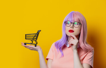 Girl with purple hair and pink dress with black shopping cart