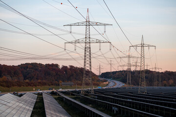 Renewable energy, large field of solar panels, solar panels and high voltage electricity pylons...