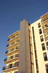 White modern apartments building facade in sunlight on a sunny day with clear blue sky. Vana - Kuuli street.