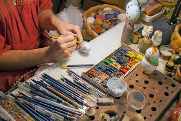 An artist painting an egg for tourists in Mandrogi, Russia.