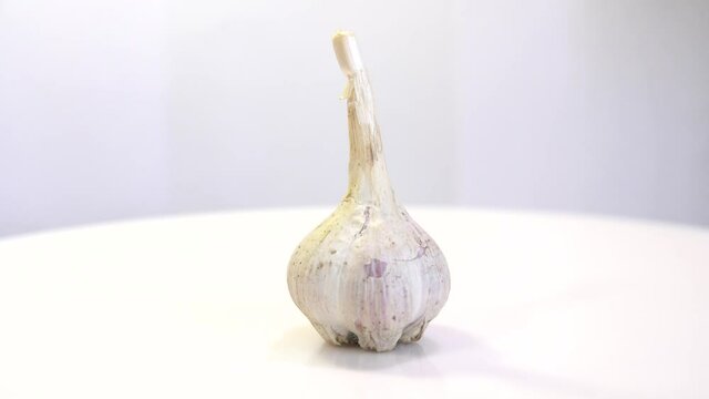 rotating garlic head on wite background.