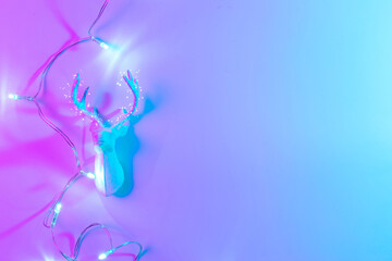 Deer lights neon Christmas winter background. Minimal abstract xmas reindeer. Holiday decoration bauble ball on neon gradient backdrop. Minimal new year card.