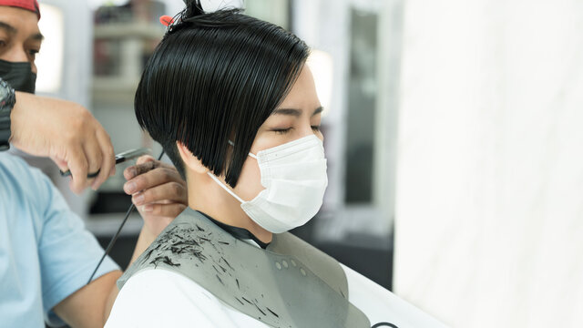 A Beautiful Asian Woman With Face Covering Relaxing Getting Haircut At A Salons During Covid 19 Pandemic. New Normal, Face Mask Required, Bob, Pixie Cut, Leisure, Lifestyle, Professional, Satisfied.