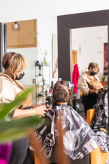 Latin small business Beauty salon. Entrepreneur hairdresser woman and mixed race client. Facemask