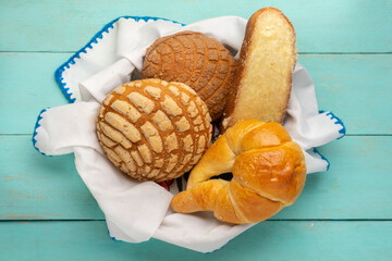 Basket with Mexican sweet breads on a turquoise background.