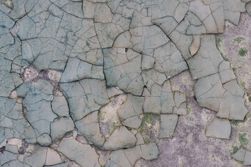 Peeling paint on the wall. Old concrete wall with cracked flaking paint. Weathered rough painted surface with patterns of cracks and peeling. High resolution texture for background and design. Closeup