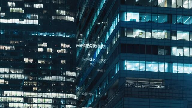 Time lapse blinking office windows lights in business center building facade, people working late night. Corporate business, high skyscraper glass surface. Light in building windows turn on and off