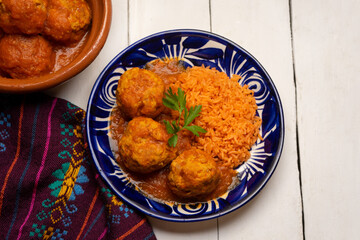meatballs with red rice and tomato broth on a white background. Mexican food