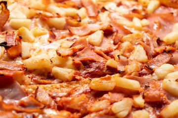 Ham and pineapple pizza called hawaiian on a wooden background