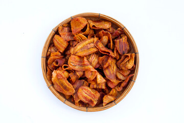 Banana slice chips in round bamboo basket on white background.