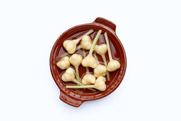 Pickled garlic in bowl on white background.