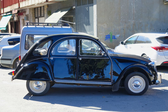 Side view of a shiny black Citr&ouml;en 2cv parked in the street