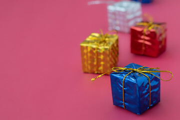 close up small wrapped gift boxes with red background and copy space