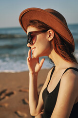 pretty woman in hat and sunglasses on the beach walk sun