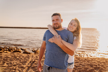 a man and a woman in love hugging and having fun on the sea beach. solar glare