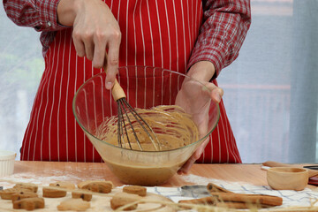 Homemade Christmas cookies, bakery man preparing gingerbread cookies dough, mixing ingredient together in the bowl by using whisk, kneading the dough, food homemade bakery concept