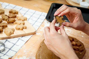 Homemade Christmas cookies, bakery man preparing gingerbread cookies dough, hand cutting dough by...