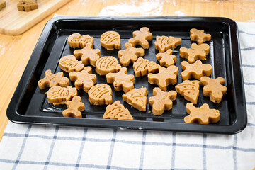 Christmas gingerbread cookies on tray, homemade cookies before baking, making Xmas ginger bread, preparing bakery, process of baking and cooking at home