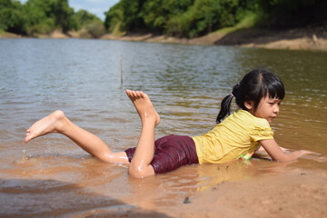 a asian girl play water on the beach river