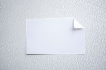 detalle de tarjeta de cartón o papel blanco con la esquina doblada 