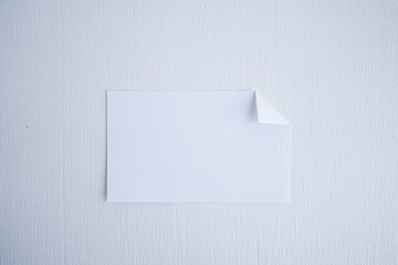 detalle de tarjeta de cartón o papel blanco con la esquina doblada 