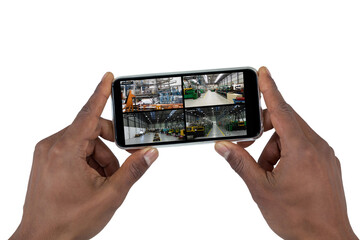 Hands of african american man holding smartphone, view of warehouse from security cameras on screen