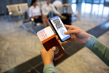 Woman at airport holding documents and smartphone with covid 19 vaccine passport at check in