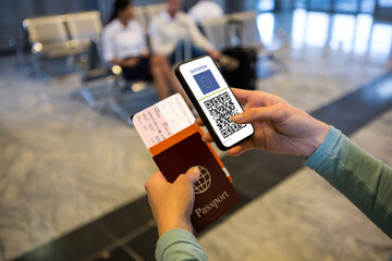 Woman at airport holding documents and smartphone with covid 19 vaccine passport at check in