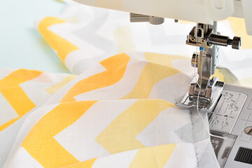 Modern sewing machine and yellow fabric in zigzag.
