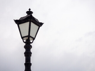 Fototapeta na wymiar A beautiful street lamp on a background of a gray sky.