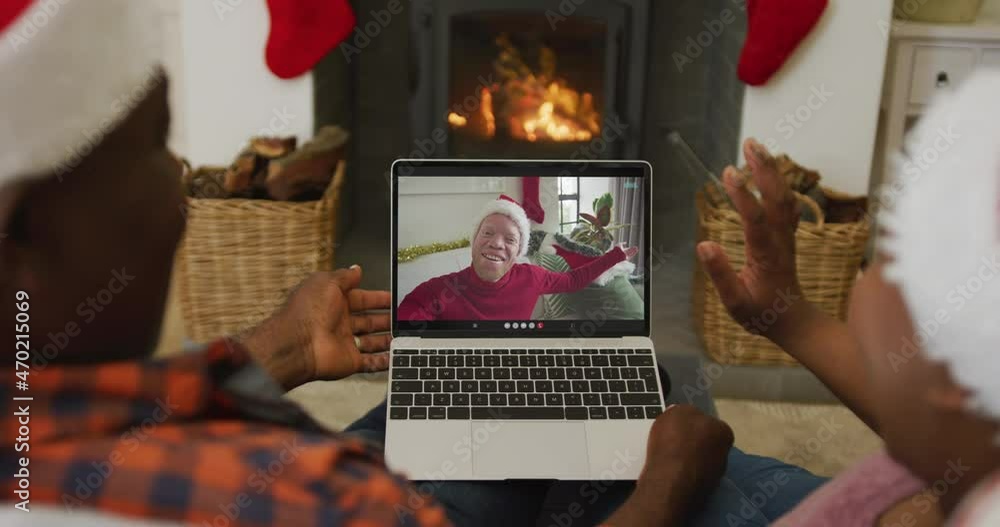 Canvas Prints African american couple with santa hats using laptop for christmas video call with man on screen