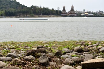 Round pebbles stones lakeside landscape coast view with twin pagodas in the background