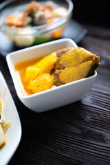 Sea bass in Tamarind Flavor Sour Soup Southern Thai Recipe with pineapple , thai food and vegetable in white bowl