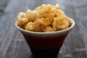 Homemade deep fried crispy pork rind in bowl.