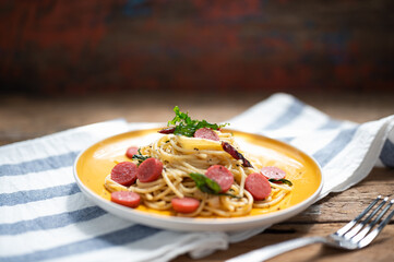 Spaghetti spicy with sausage in yellow dish