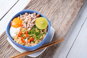 Instant noodles with minced pork and egg in bowl.