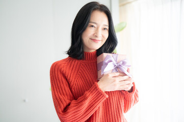 Beautiful Asian (Japanese) woman holding a gift Close-up copyspace