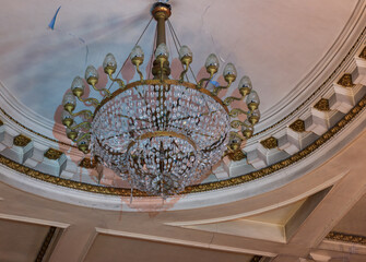 a rickety chandelier in a dilapidated house