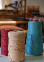 Spools of thread with weaving loom in background