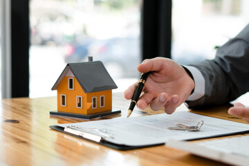 The real estate agent is explaining the house style to the clients who come to contact to see the house design and the purchase agreement.