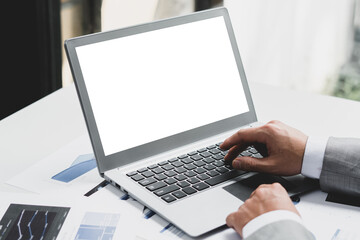 businessman typing on a laptop with blank screen in a coworking space, clipping path.