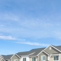 Square Front view of townhouses against blue sky on a suburban neighborhood landscape