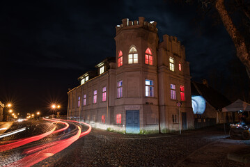 House with a tower with lights on the windows in different colors. Day of proclamation of the Republic of Latvia